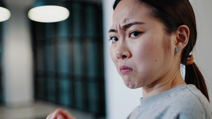 Woman reacts to unpleasant smell with displeasure and confusion in indoor setting