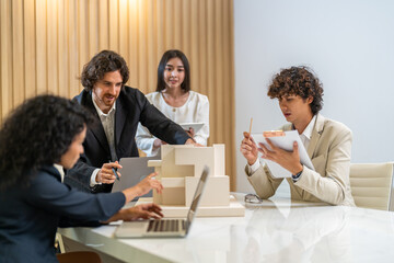 Architects engineers collaborating on building design project in modern office, diverse team of professionals female muslim architect and male engineers discussing architectural model of structure