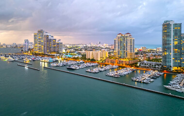 Fototapeta premium Cityscape of downtown Miami at night light. Tropical paradise in South Beach. Midnight city lights in Miami. Waterfront view of Miami skyline. Aerial shot of Miami at sunrise. Neon Art Deco. Ocean