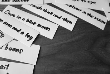 英語のイディオムのカードが片側に置かれた白黒の背景