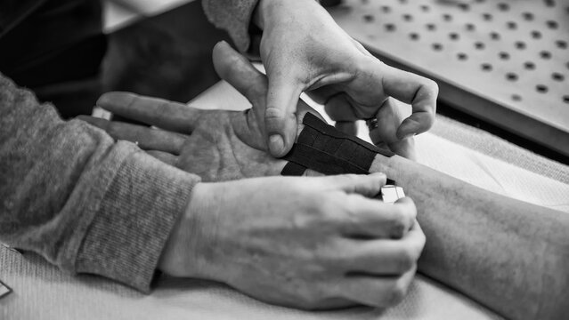 Medical therapy using pain relief patches on a female patient’s wrist in a physiotherapy clinic - Powered by Adobe
