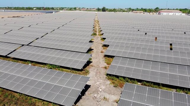 Rare aerial ascension overview of African solar farm for sustainable renewable energy but with very dirty dusty solar panel arrays