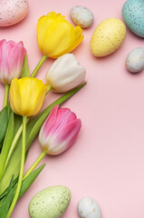 Colorful easter eggs and tulips creating festive border on pink background
