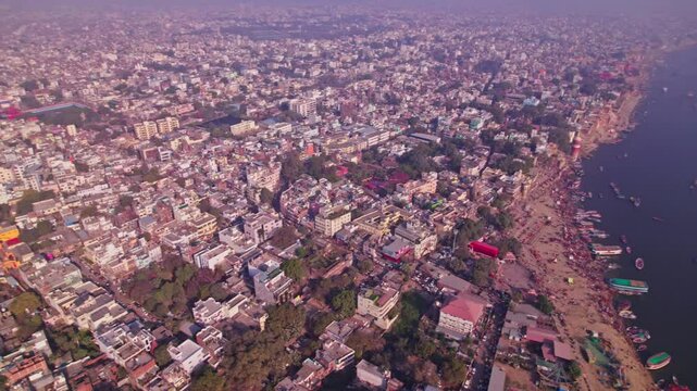 Varanasi city view through ganga river with varanasi ghats or kashi ghats at banaras, kashi, uttar pradesh, india. day time, orbit shot, drone shot, 4k.
