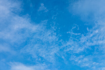 Bright blue sky with scattered fluffy white clouds. Clear daytime view