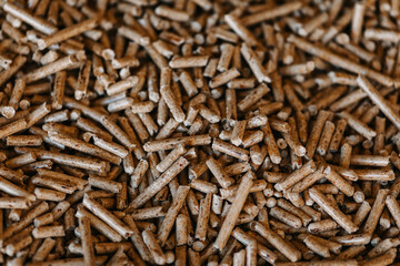 A close-up of wood pellets used as biofuel. The natural texture and warm brown tones create an eco-friendly and organic look. A great choice for illustrating topics related to renewable energy, heatin