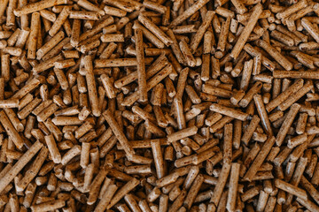 A close-up of wood pellets used as biofuel. The natural texture and warm brown tones create an eco-friendly and organic look. A great choice for illustrating topics related to renewable energy, heatin