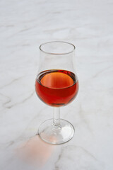 Elegant glass of rich amber brandy on a marble table surface