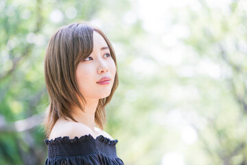 Fototapeta premium 緑あふれる公園でくつろぐ女性