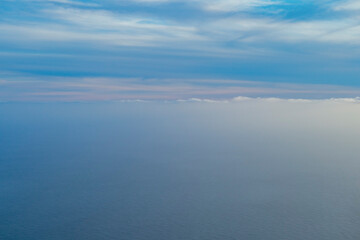 Fototapeta premium 飛行機の窓から見える空と海