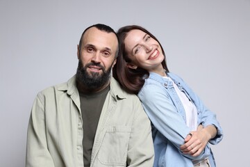 Portrait of happy daughter and father on light grey background