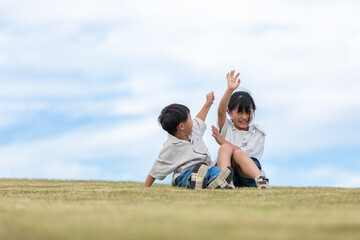 草原で戯れ合う子供