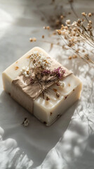 Delicate soap bar wrapped in biodegradable paper with dried flower accents, organic feel, soft shadows, white background