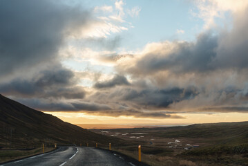 Highway view of morning sun filtering through moody Icelandic sky