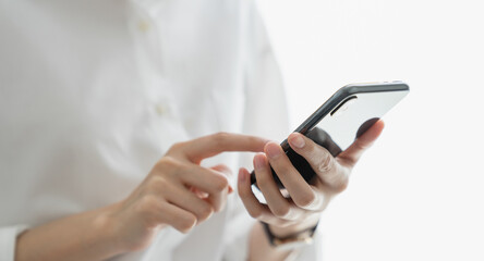 Close-up of hand holding smartphone device and typing text message on online social.