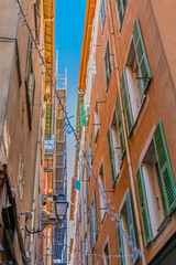 Narrow alleyway with shuttered windows and hanging string lights
