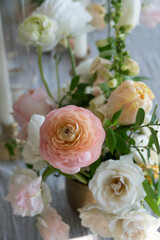 Pastel ranunculus and roses in soft floral centerpiece arrangeme