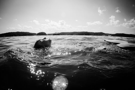 Person floating peacefully on a lake in sunlight