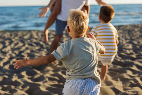 Children running on the beach towards parents during summer vacation - Powered by Adobe