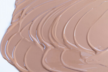 Chic cosmetic background of liquid foundation of coffee tone. Soft beautiful waves of liquid powder. The texture of a makeup makeup. A sample product