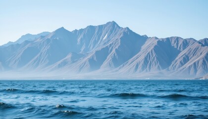 The majestic mountain range towers above a tranquil scene, with a striped wave pattern forming in the distance