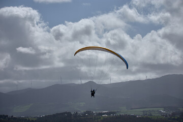 Paraglider in action against dramatic clouds at Faro de San Agustin, Asturias