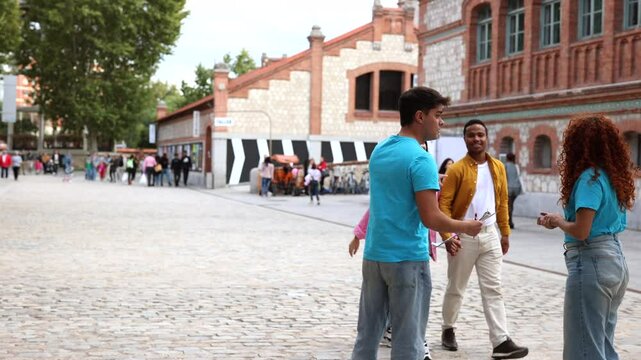 Four young volunteers, two men and two women, are collecting signatures for a petition on a city street, engaging with passersby and explaining their cause