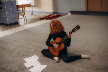Young Woman Practicing Guitar on Carpet in Cozy Indoor Setting