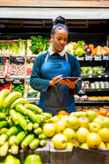 Saleswoman using digital tablet while working at organic supermarket