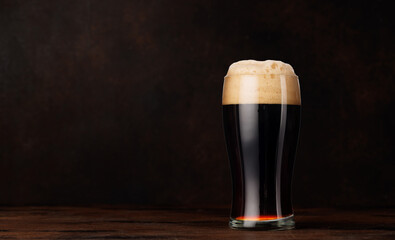 A glass of stout beer with a frothy head