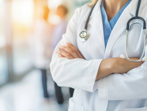 Confident female doctor in white coat with stethoscope, arms crossed, exuding professionalism and care in medical environment