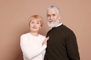 Portrait of lovely senior couple on beige background