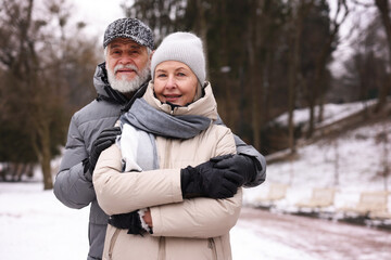 Portrait of happy senior couple at winter park. Space for text