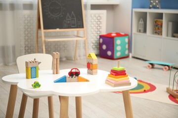 Child's playroom with different toys, blackboard and furniture
