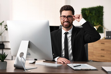 Obraz premium Man with glasses working at table in office
