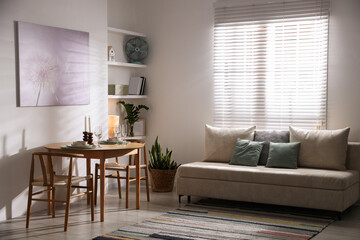 Stylish table setting, chairs and sofa in dining room. interior design