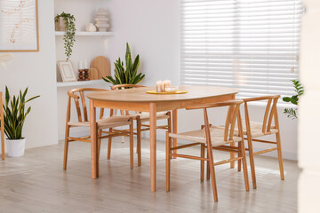 Stylish wooden table with chairs and decor indoors. Interior design