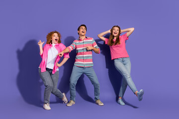 Fototapeta premium Happy Group of Young Friends Having Fun and Posing Against a Vibrant Purple Background, Showcasing Joyful Expressions and Playful Gestures