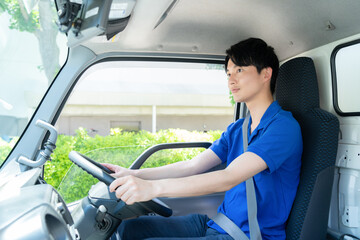 トラックで配達をする若い男性ドライバー
