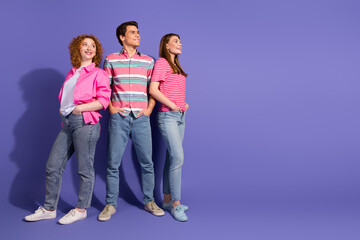 Fototapeta premium Young friends standing together in colorful shirts against a purple background, showcasing diversity