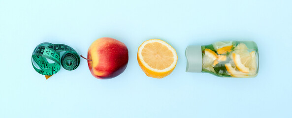 Layout on blue background. Roulette, bottle, orange and apple. Fitness symbols billboard