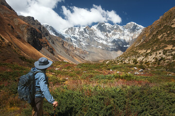 Hiker with backpack against picturesque mountain landscape during Annapurna Circuit trek in Himalayas, Nepal.