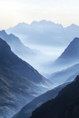 Fototapeta premium Breathtaking view of snow-capped peaks, misty valleys and a river winding through the terrain.