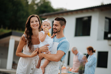 Portrait of young family during spring outdoor barbecue.