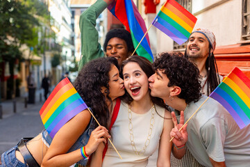 Fototapeta premium Friends kissing woman cheeks at gay pride parade