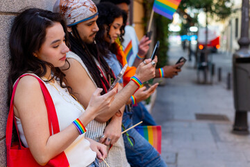 Young activists using smartphones during a lgbt pride parade