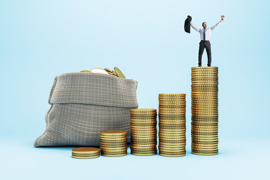 Businessman standing victoriously on stacked gold coins beside money bag, symbolizing success, savings, and financial growth on light background.