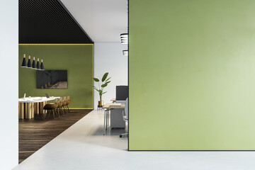 Modern office interior with green wall and elegant layout, showing a meeting area and workspaces in...