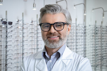 Mature caucasian man in lab coat and glasses looking determined
