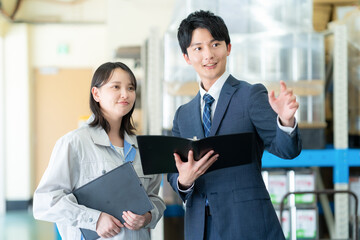 Obraz premium 倉庫で会議をする若い男女のビジネスマン
